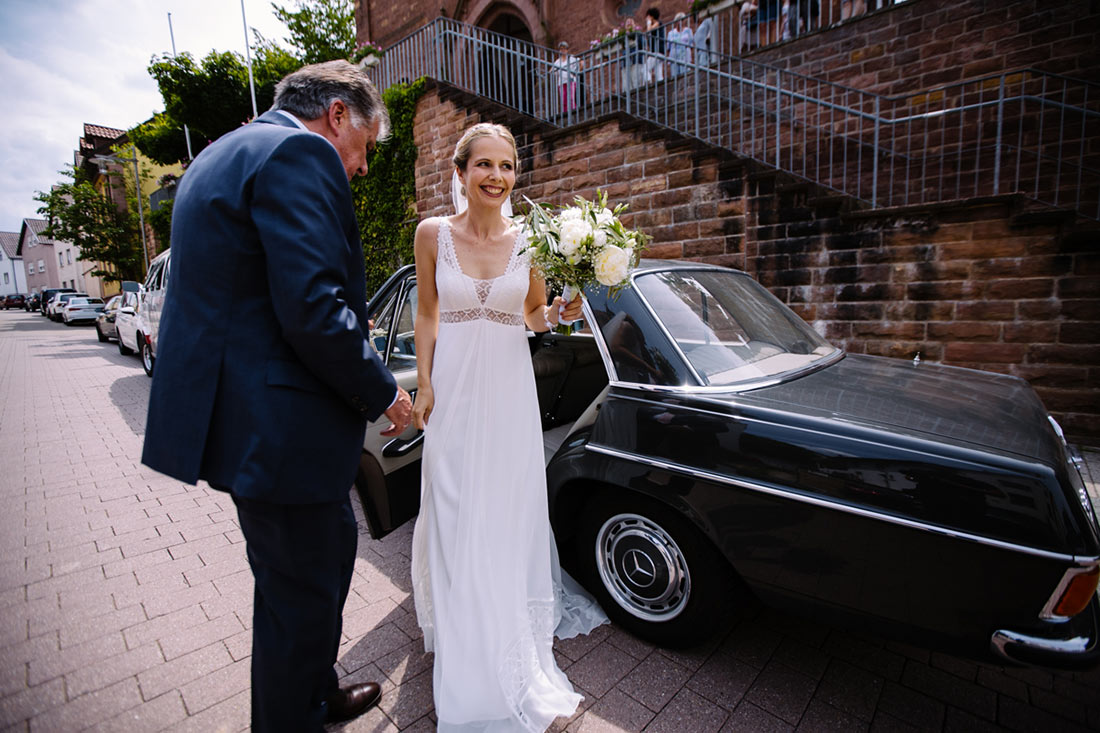 Braut steigt aus dem Hochzeitsauto